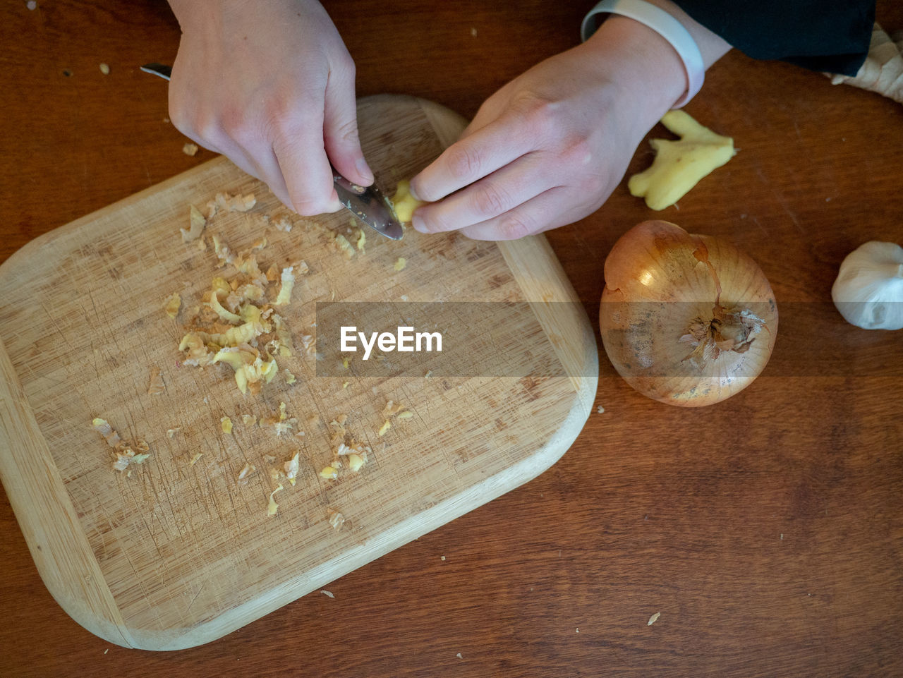 HIGH ANGLE VIEW OF HAND HOLDING CUTTING BOARD