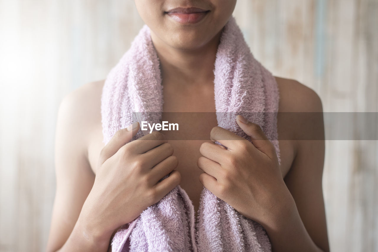 One teenage male standing while holding towel on his shoulder