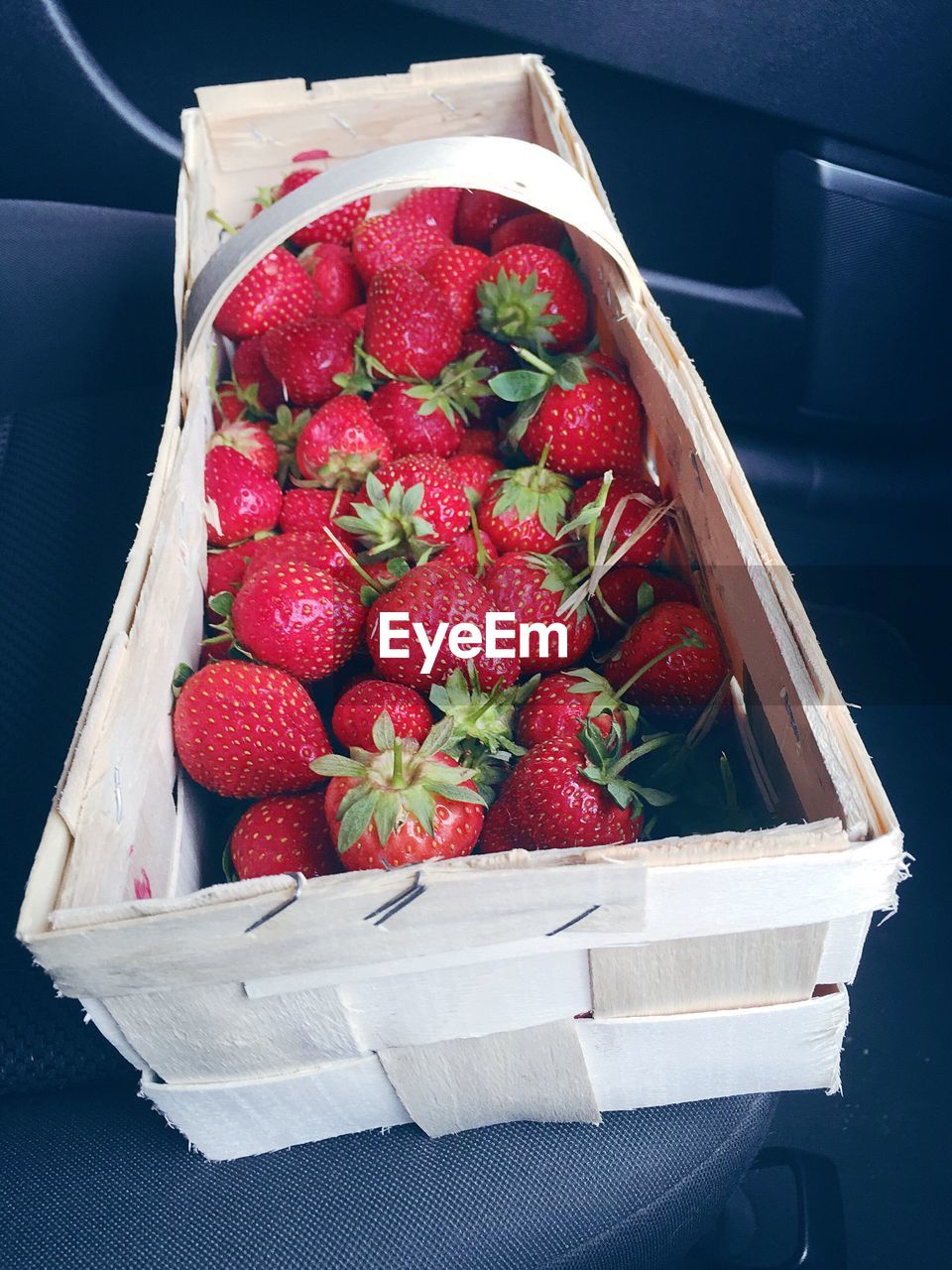 High angle view of fresh strawberries in wicker basket on table