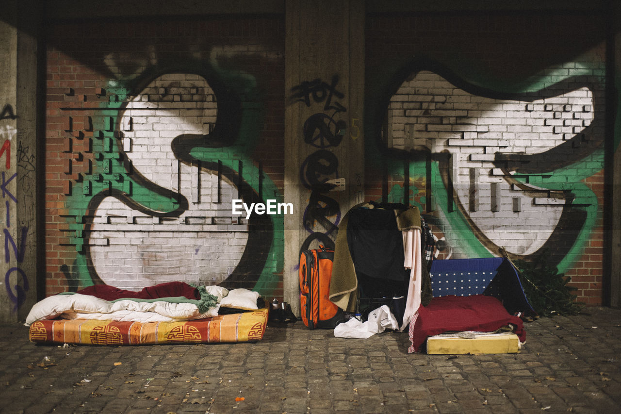 MAN STANDING BY GRAFFITI WALL