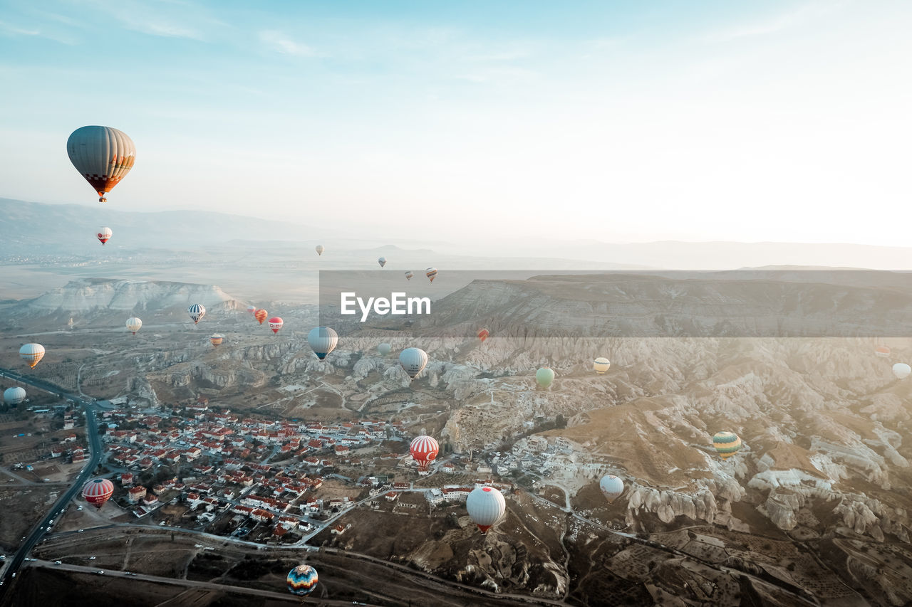 Aerial view of hot air balloons flying over landscape