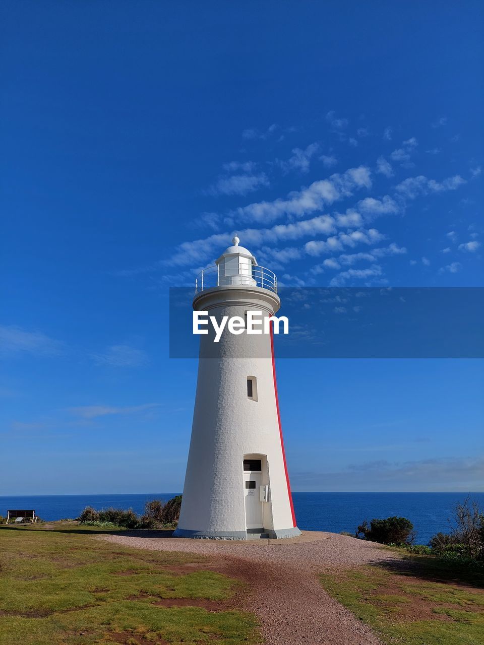 Lighthouse by sea against sky