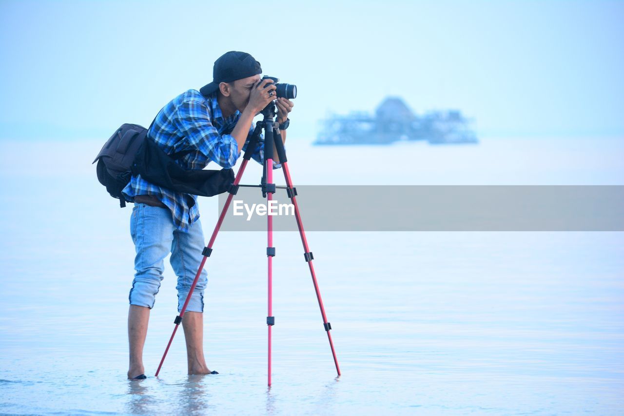 Man photographing with camera at beach