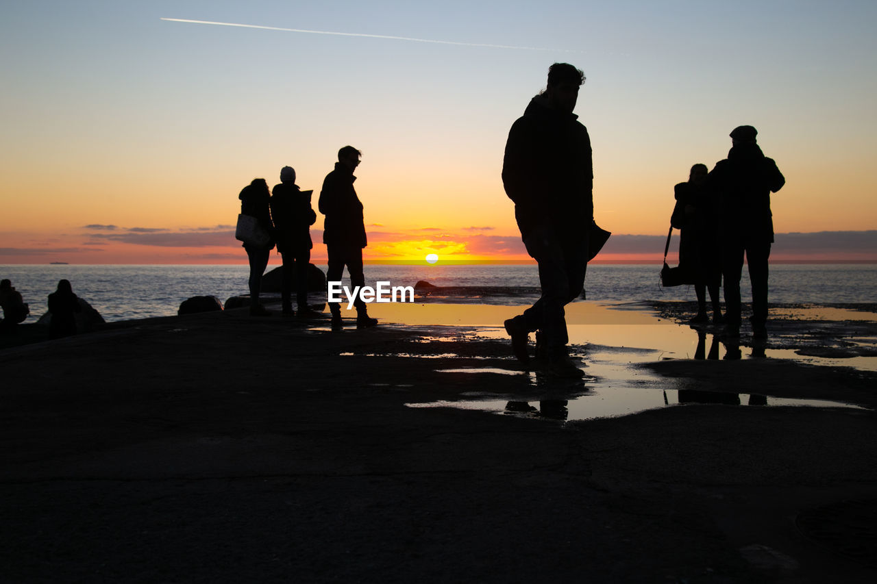 SILHOUETTE PEOPLE AT BEACH DURING SUNSET