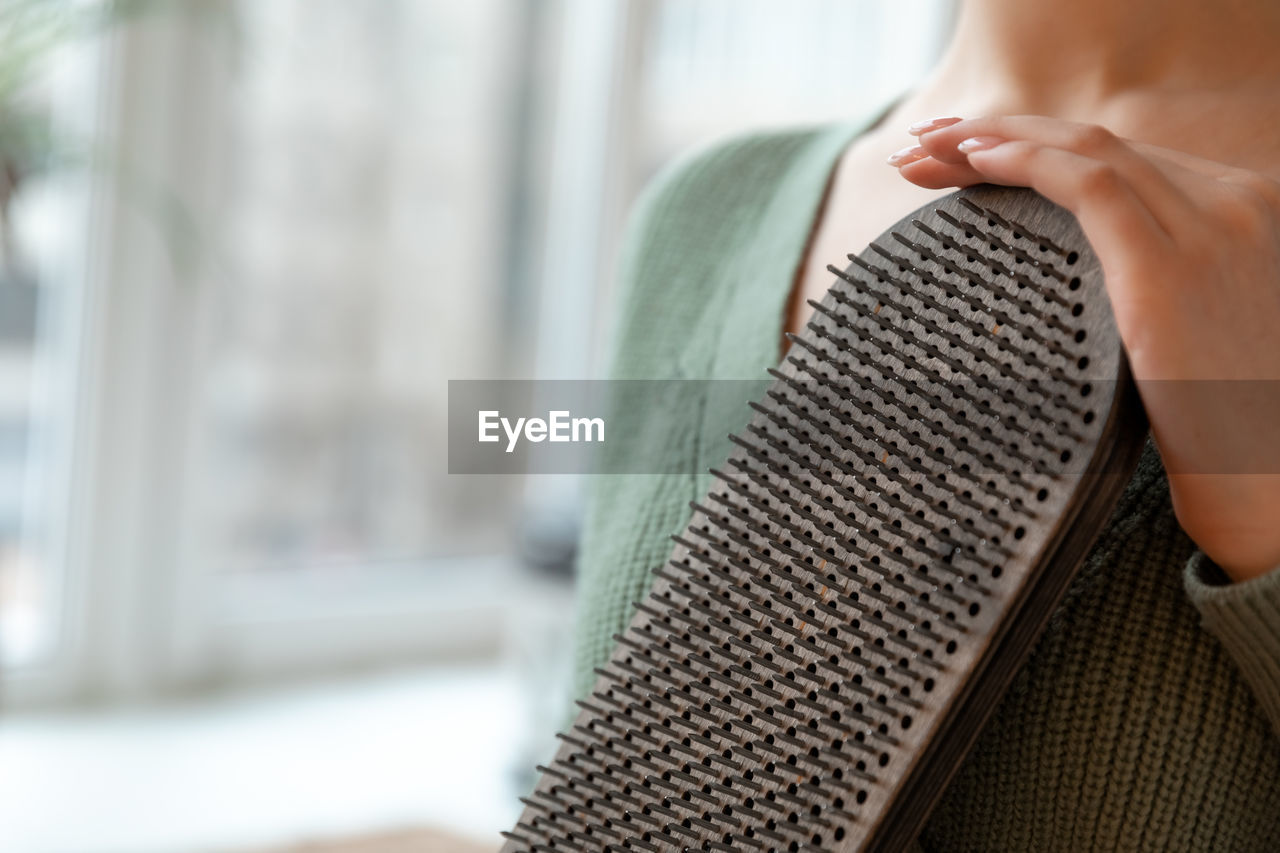 cropped hand of woman using laptop at home