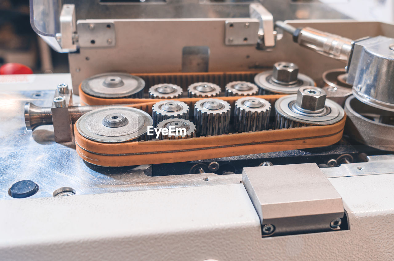 Metal gears, bolts on machine. close-up. part of industrial equipment at modern plant.