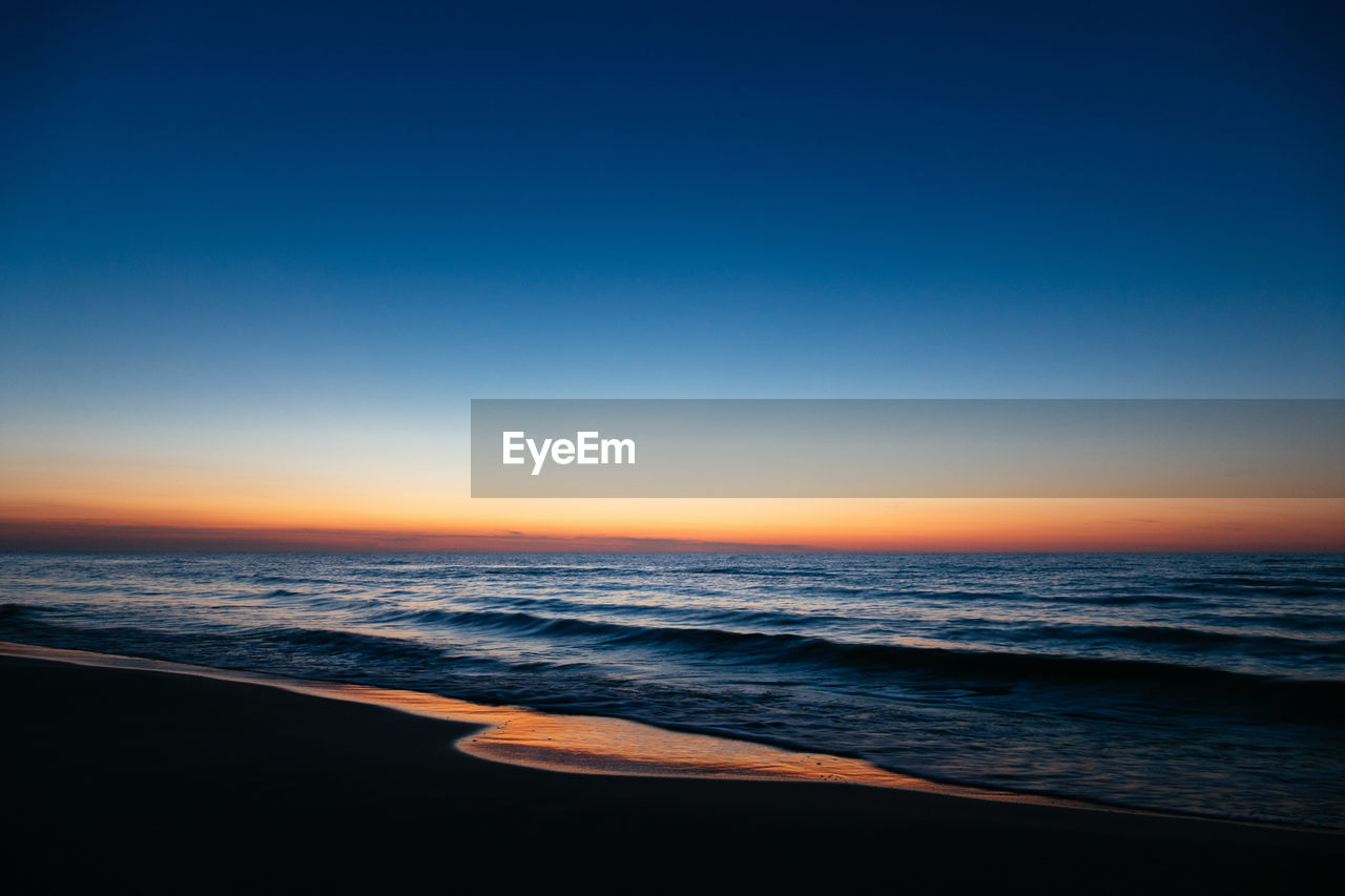 Scenic view of sea against clear sky during sunset