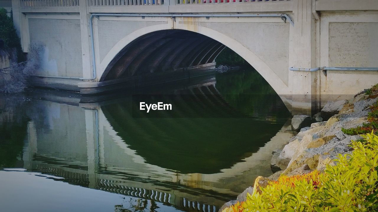 River flowing under arch bridge