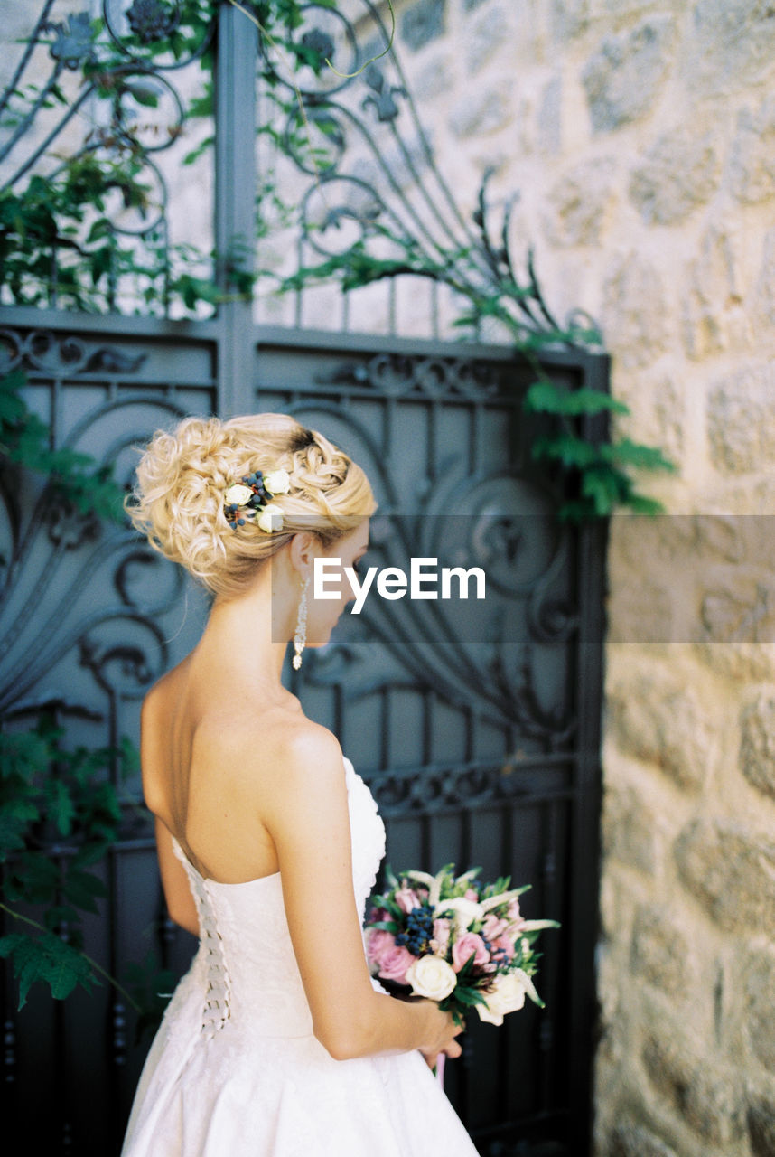 rear view of woman standing by window