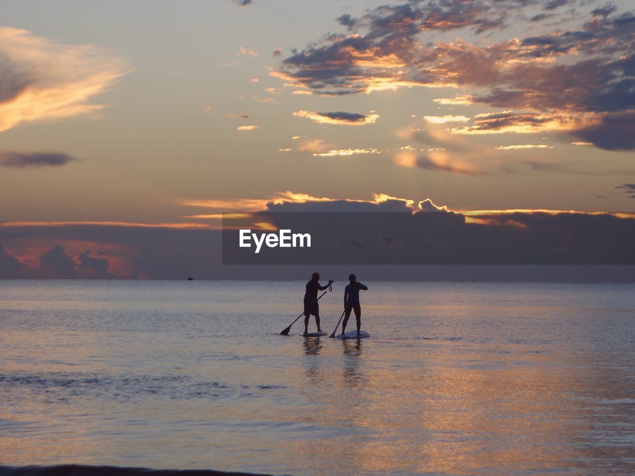 SILHOUETTE PEOPLE STANDING ON SEA AGAINST SKY DURING SUNSET