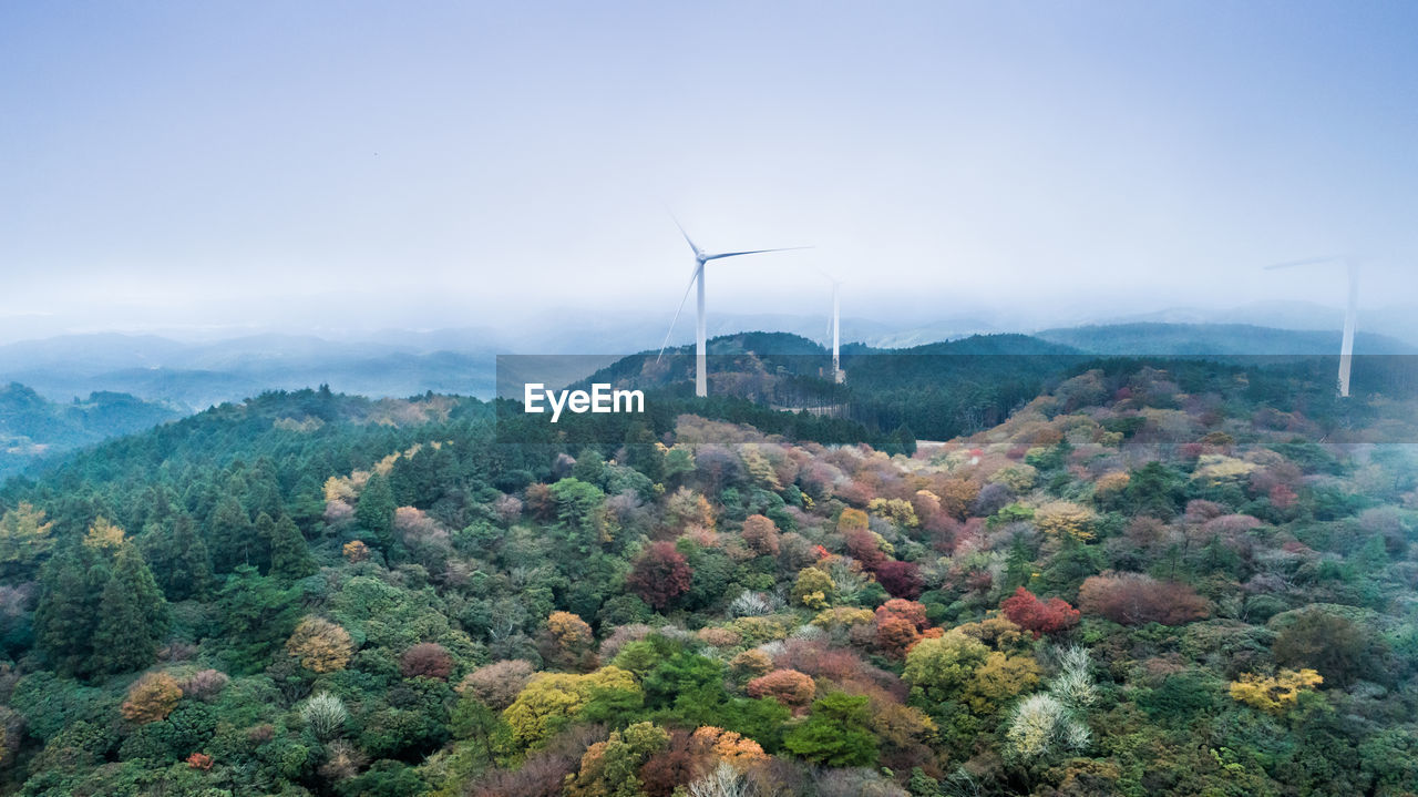 WIND TURBINES ON MOUNTAIN AGAINST SKY