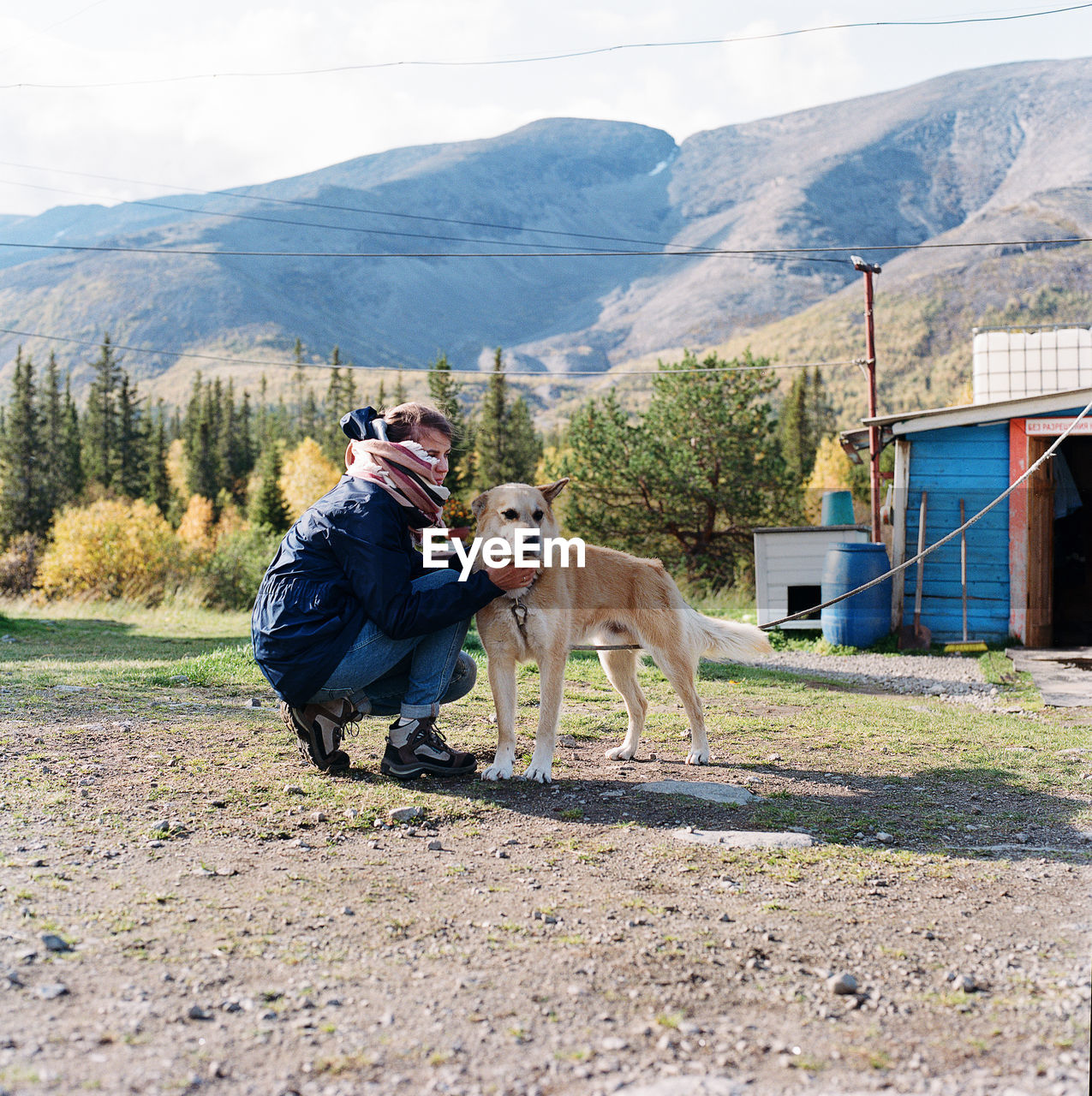 Woman sitting at the foot of the mountain with a dog