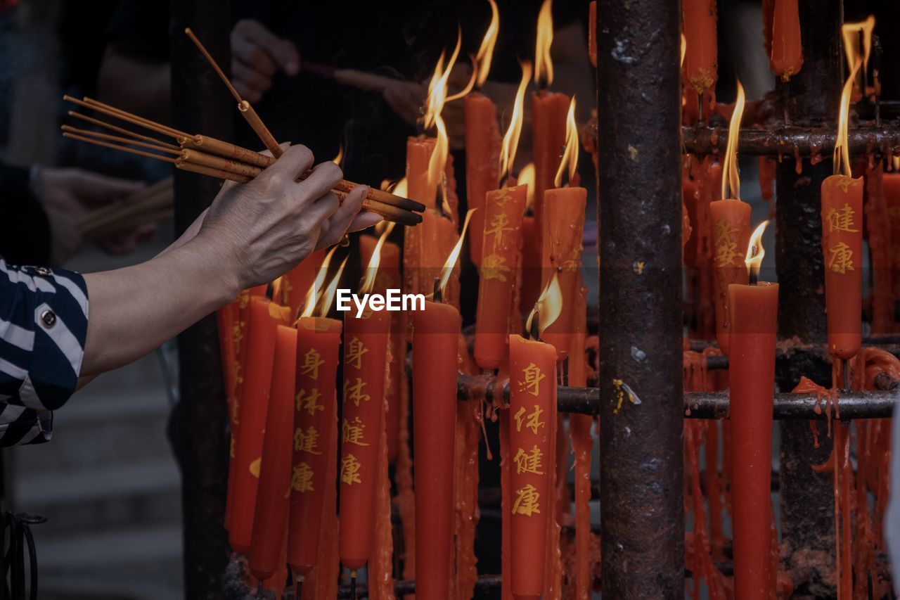 Cropped image of person holding temple against building