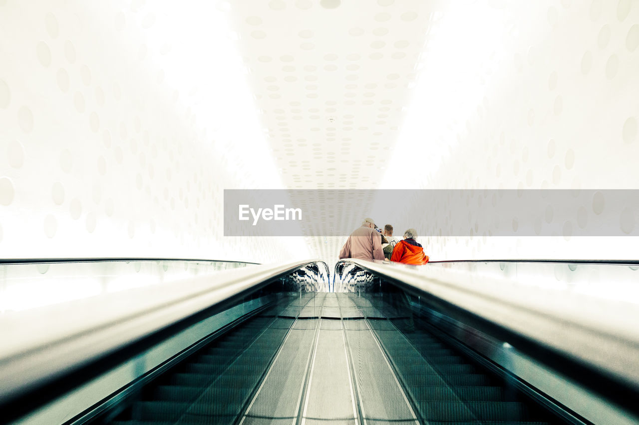 Low angle view of people on escalator