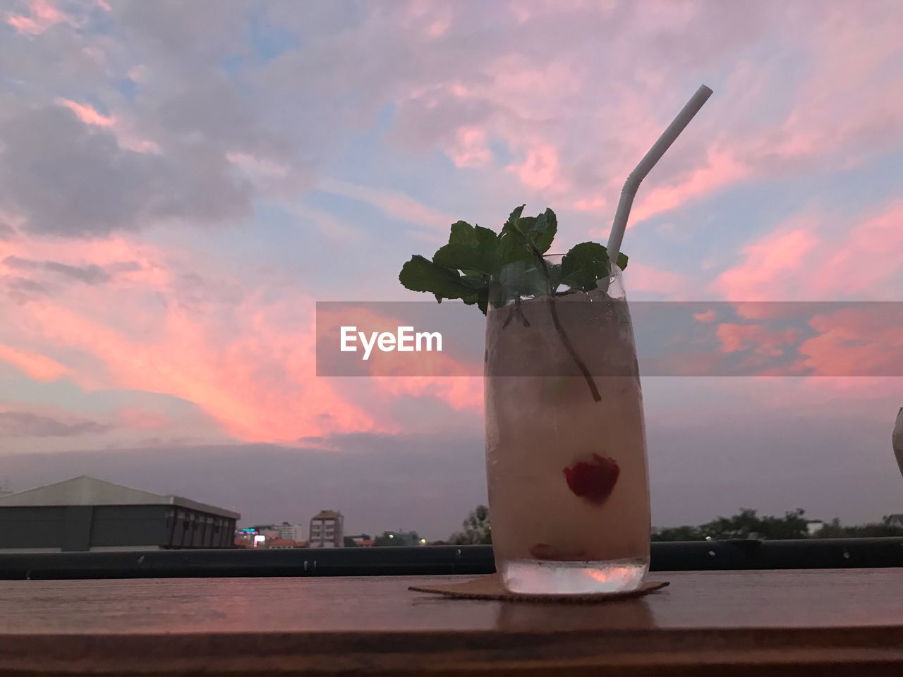 CLOSE-UP OF DRINK ON TABLE AGAINST SUNSET