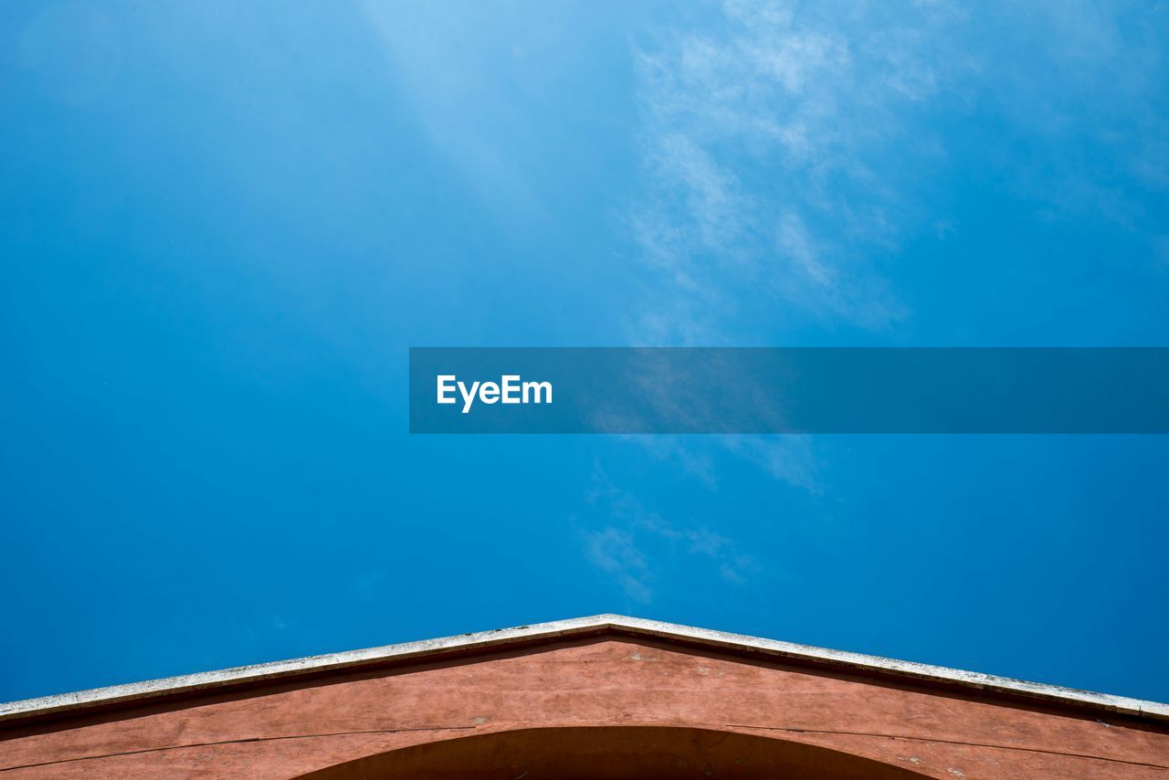 High section of wall against blue sky