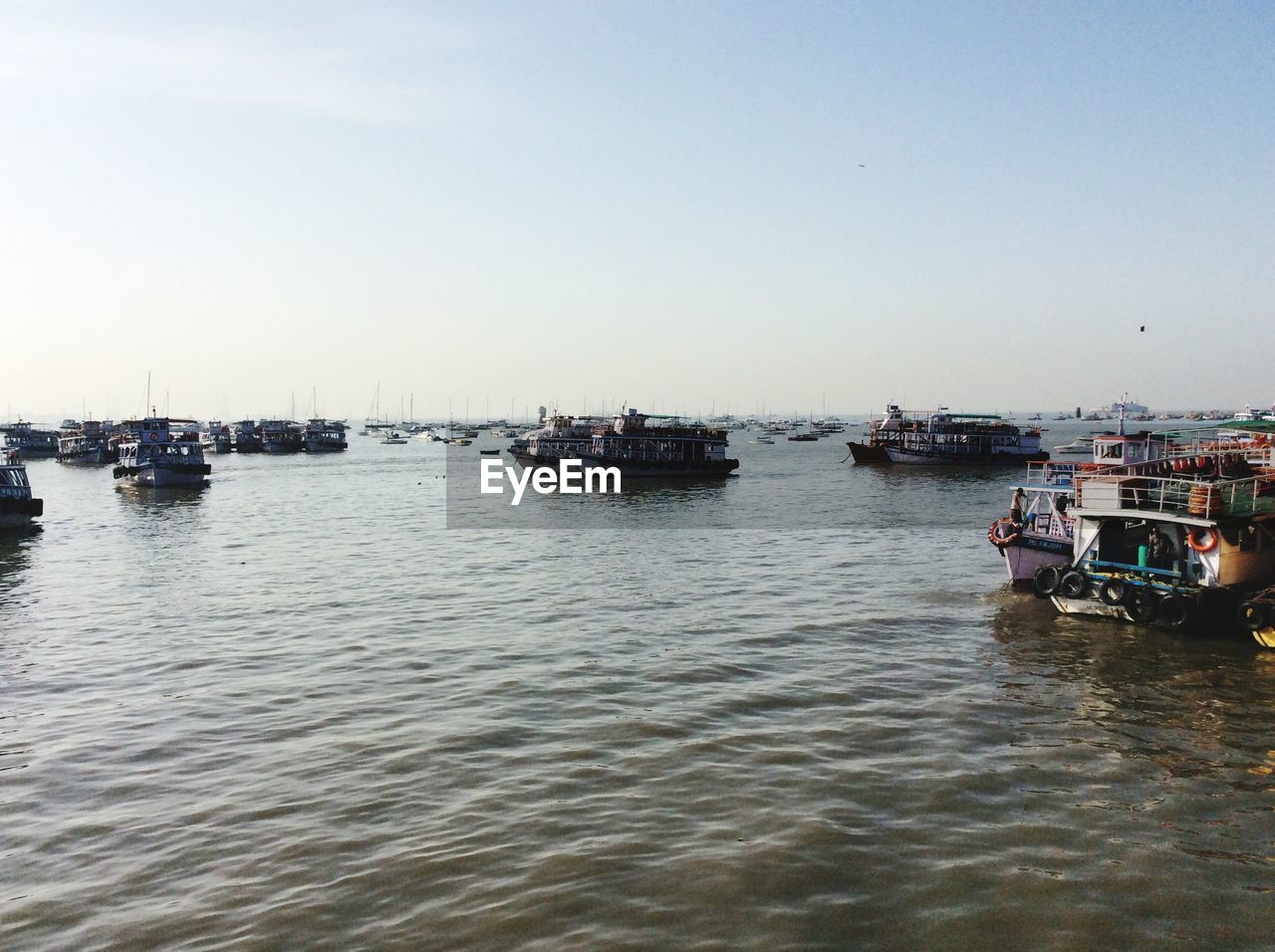 Boats sailing in sea against clear sky