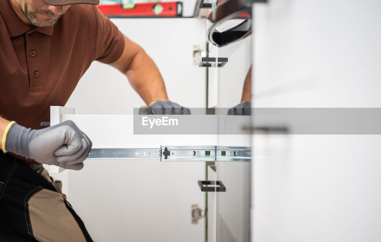 midsection of man washing hands in sink