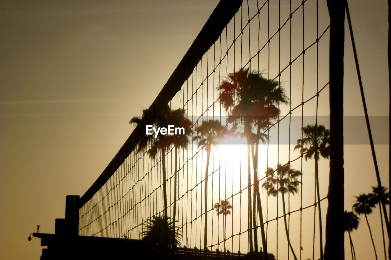 Low angle view of silhouette net against sky during sunset