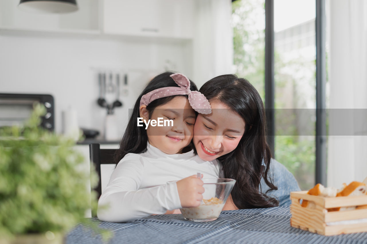 Smiling woman with daughter at home