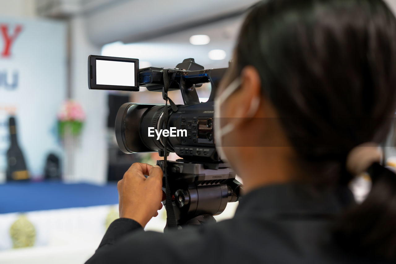 Videographer controls video cameras at trade shows.