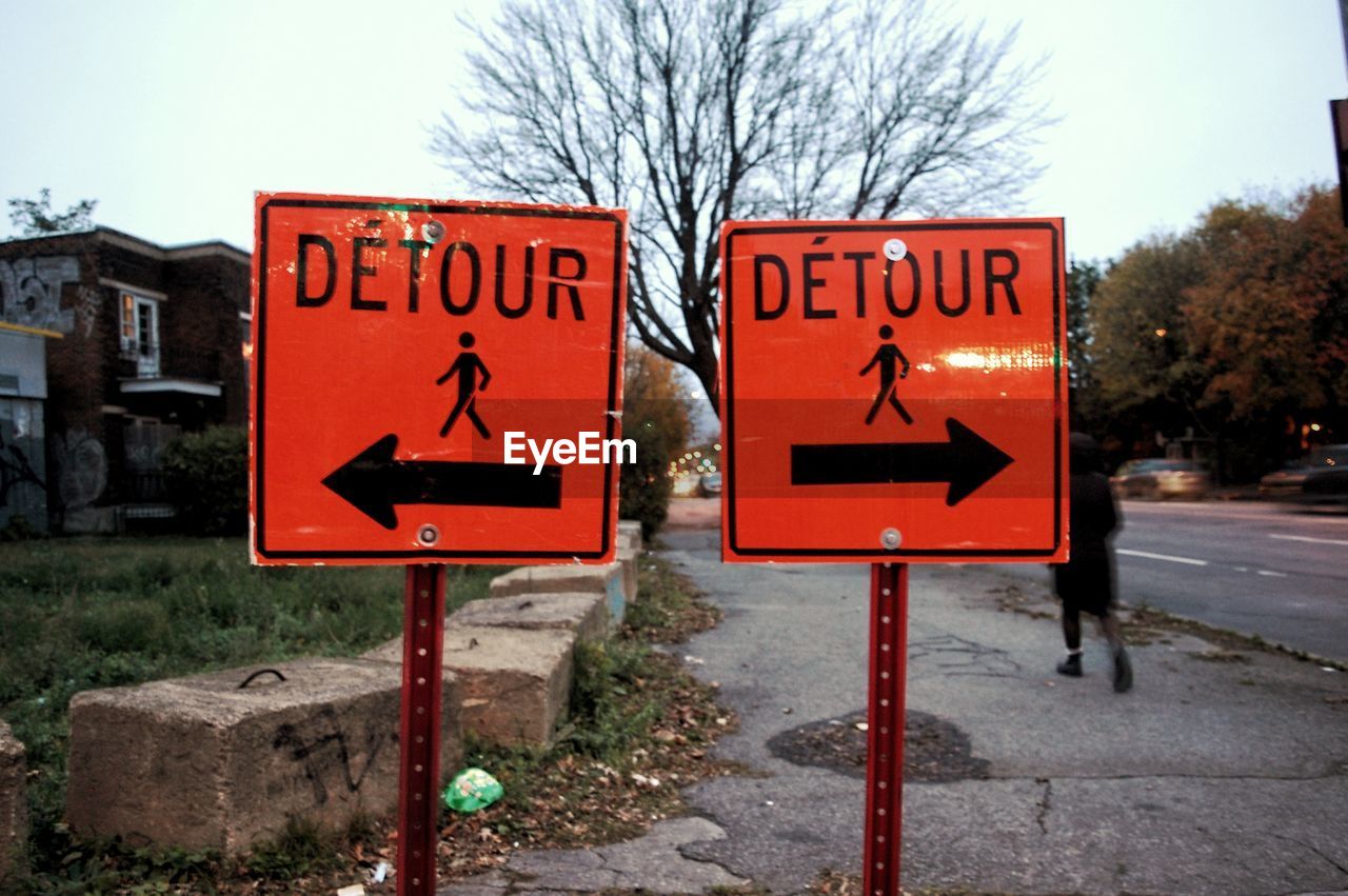 Close-up of road sign against sky