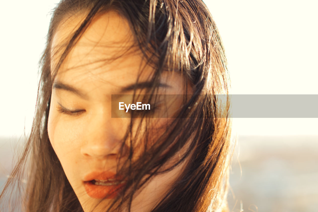 Close-up of woman outdoors in sunny day