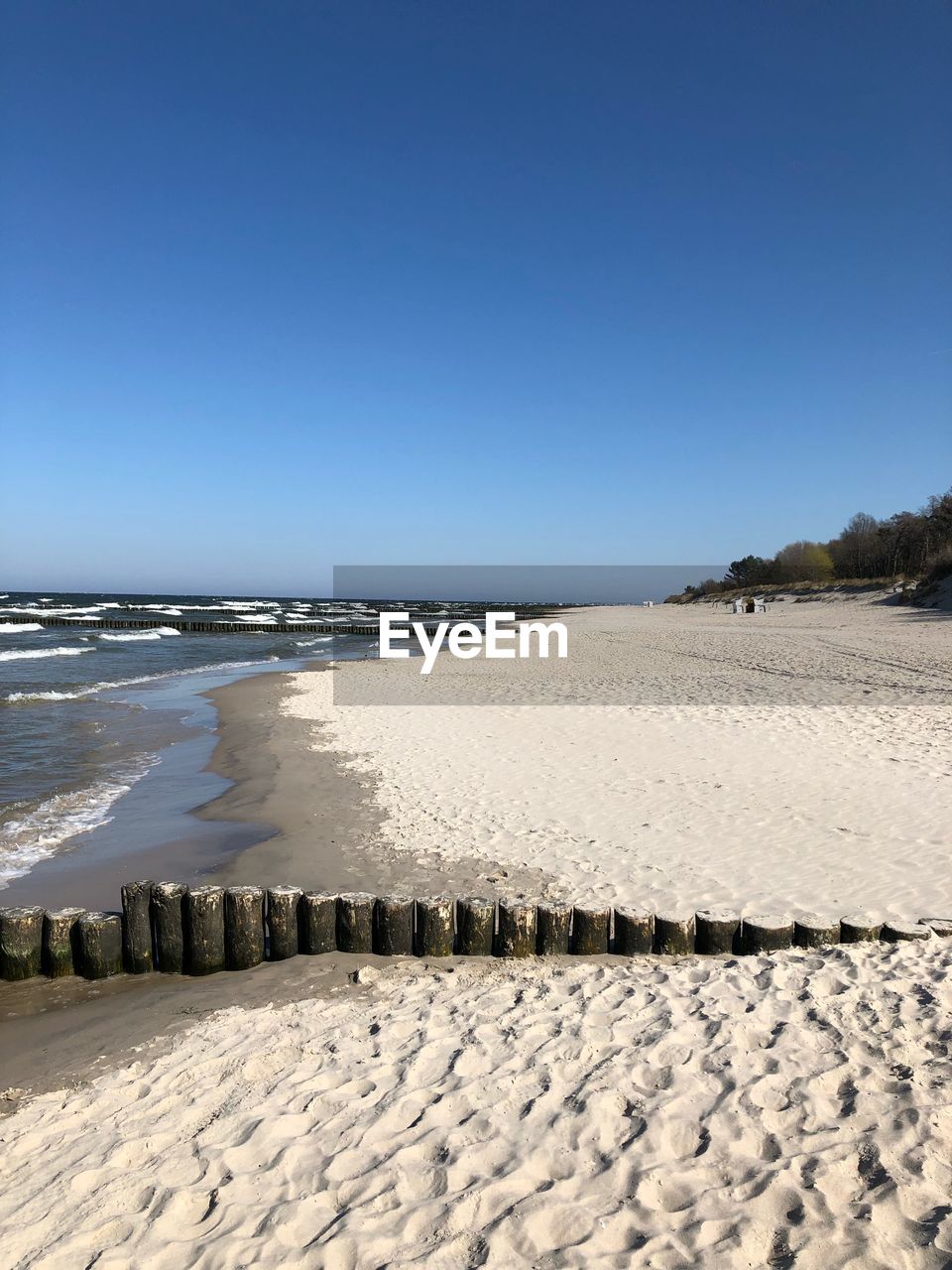 Scenic view of beach against clear blue sky