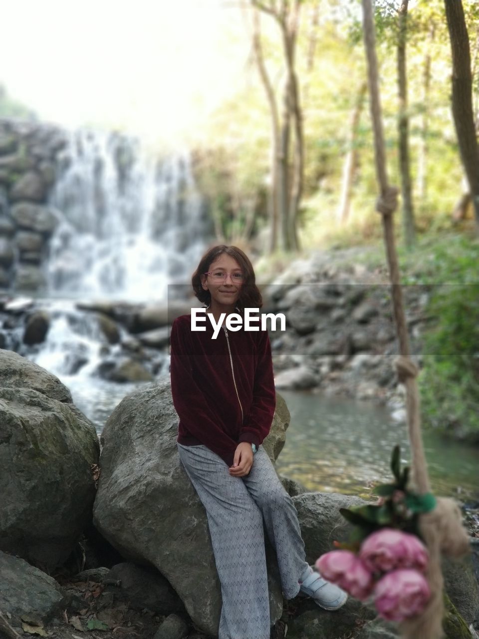 PORTRAIT OF YOUNG WOMAN ON ROCK