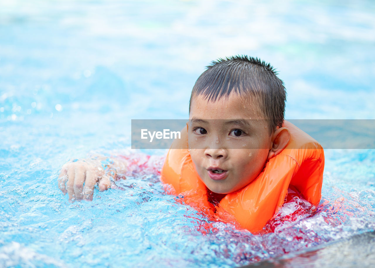 Portrait of boy swimming in pool