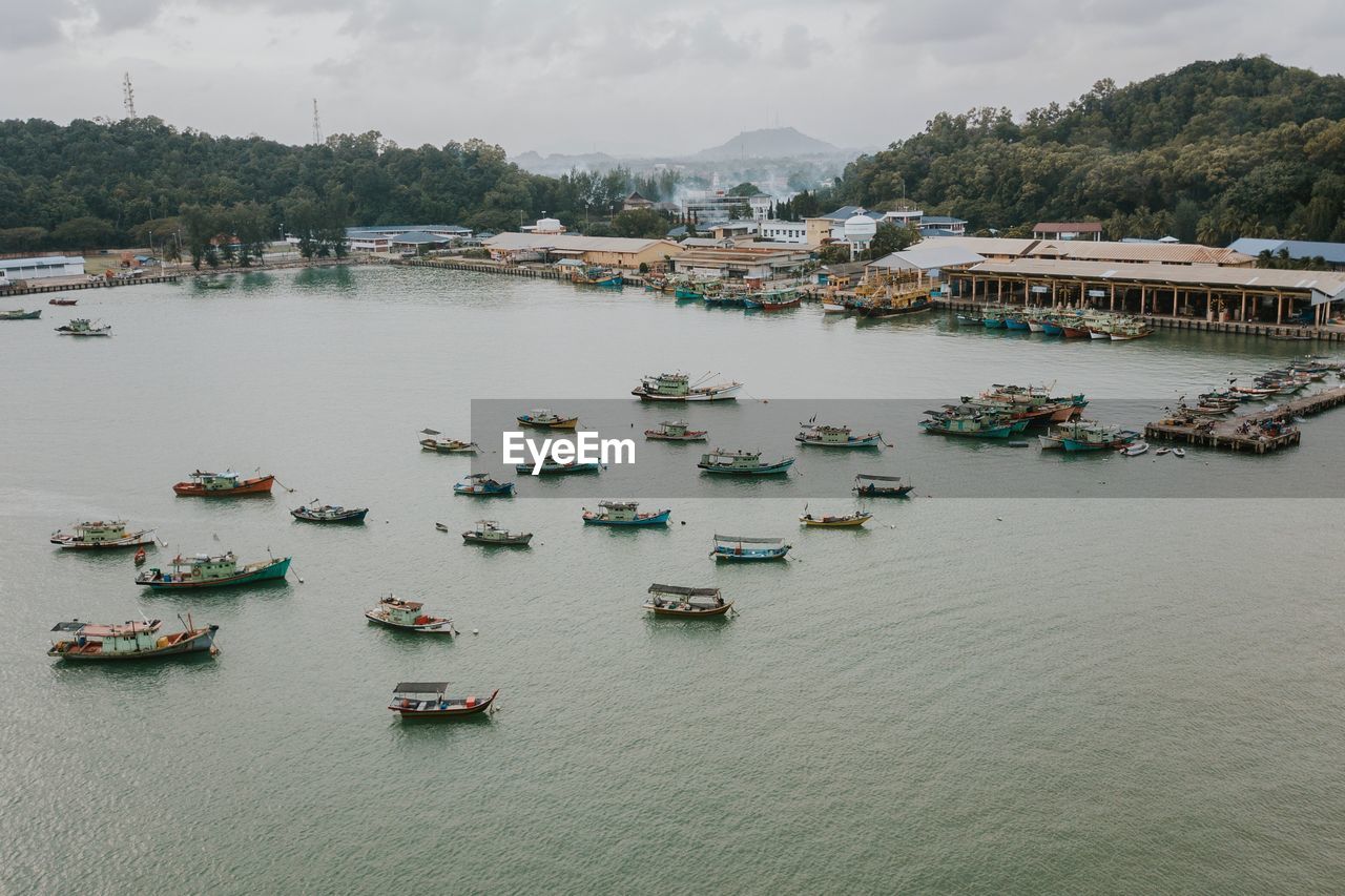 HIGH ANGLE VIEW OF BOATS MOORED ON RIVER AGAINST SKY