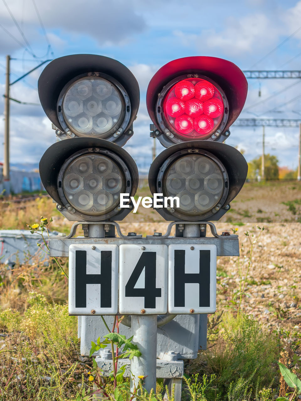 sign, communication, traffic light, nature, sky, day, no people, guidance, road sign, lighting, cloud, signaling device, text, signage, road, outdoors, grass, plant, western script, transportation, technology, warning sign, traffic sign, red