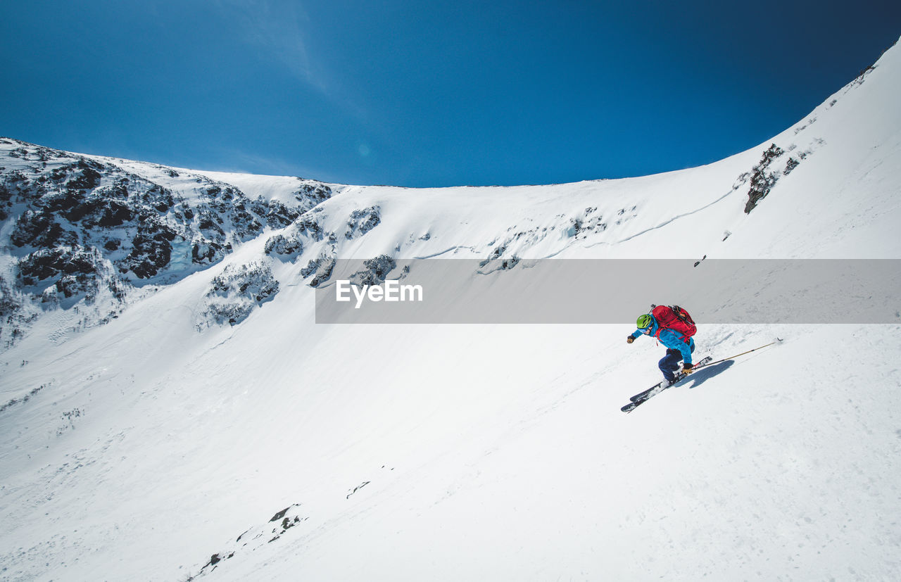Man skiing down steep terrain in tuckerman ravine, new hampshire