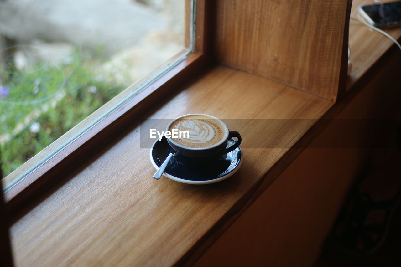 drink, coffee, food and drink, cup, mug, coffee cup, refreshment, indoors, wood, window, table, no people, hot drink, day, high angle view, still life, crockery, home interior, selective focus, cappuccino