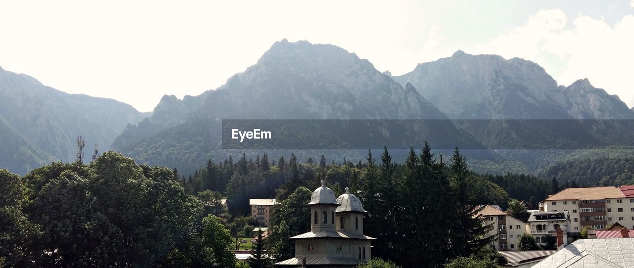 Scenic view of mountains and buildings against sky