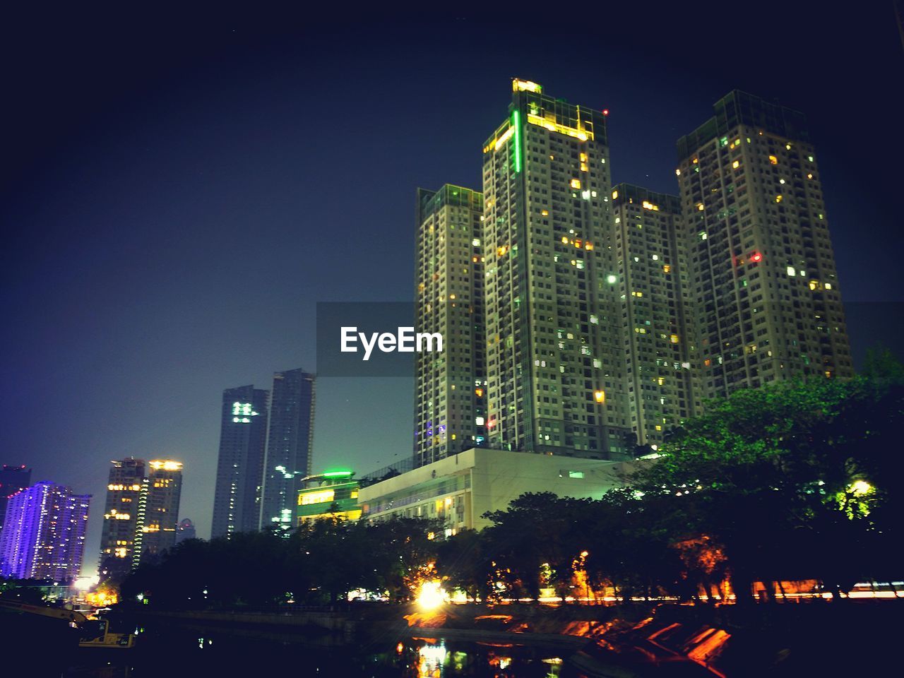 ILLUMINATED CITY AGAINST SKY AT NIGHT