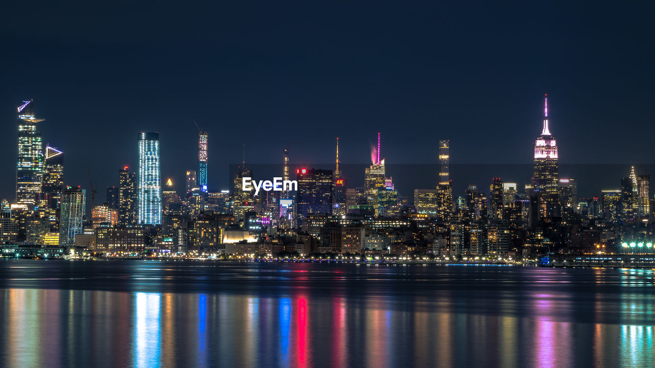 Illuminated buildings against sky at night