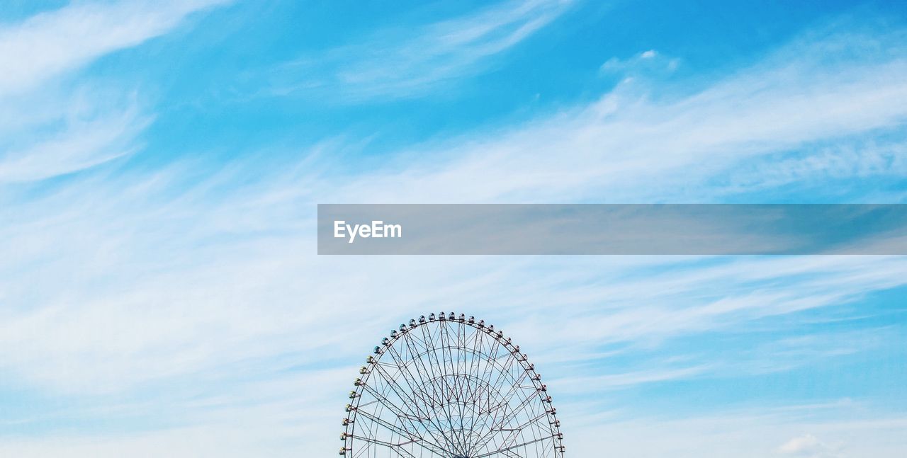 Cropped image of ferris wheel against sky