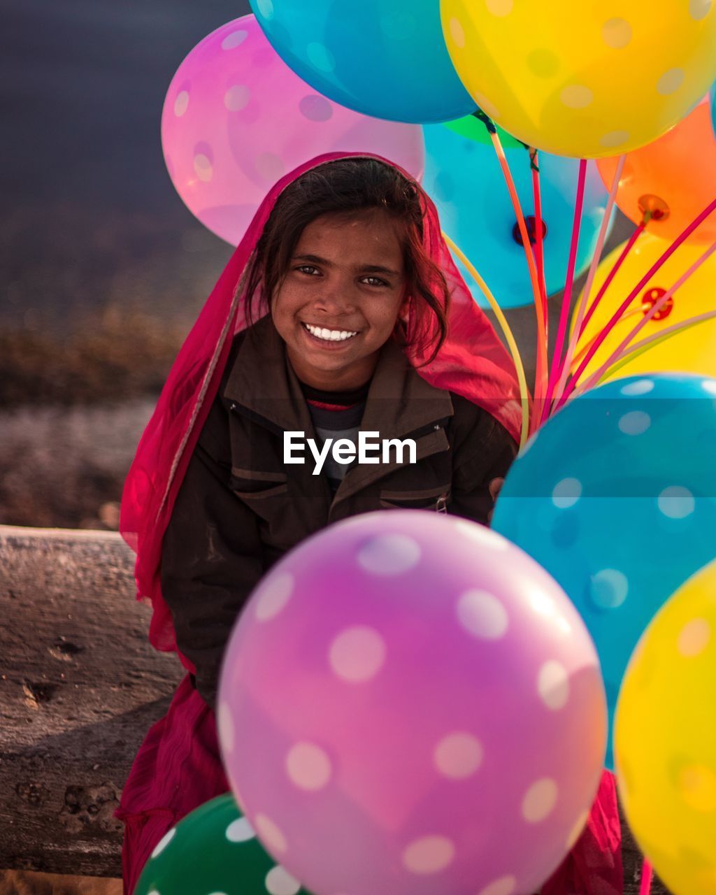 PORTRAIT OF HAPPY GIRL WITH BALLOONS