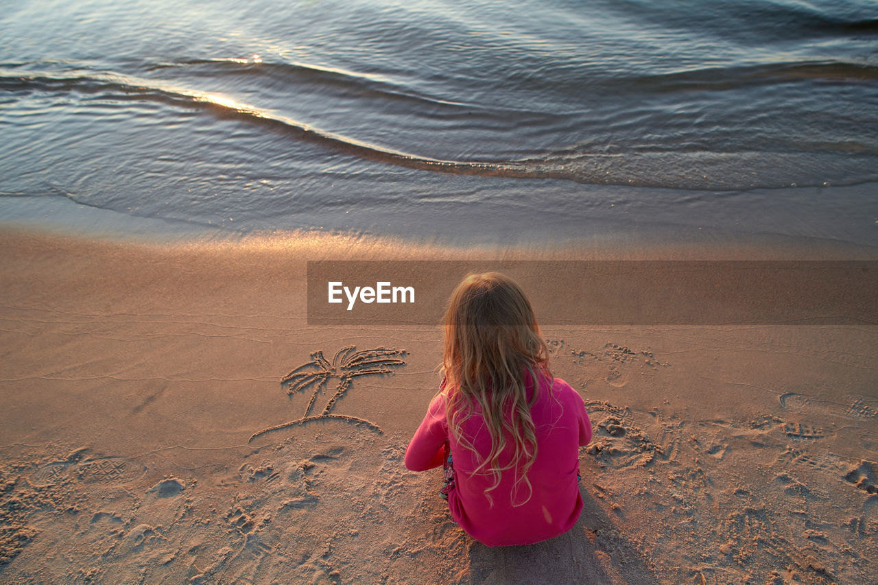 High angle view of girl sitting on beach