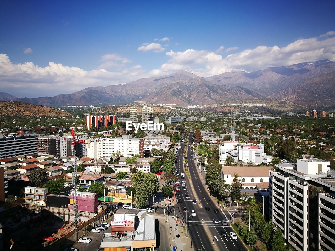 Aerial view of cityscape by mountains against sky