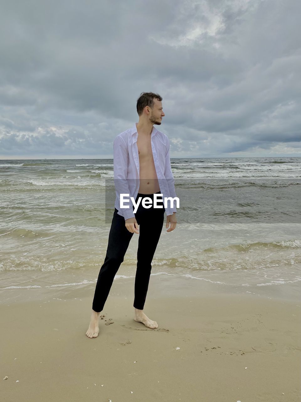 FULL LENGTH OF MAN STANDING ON BEACH