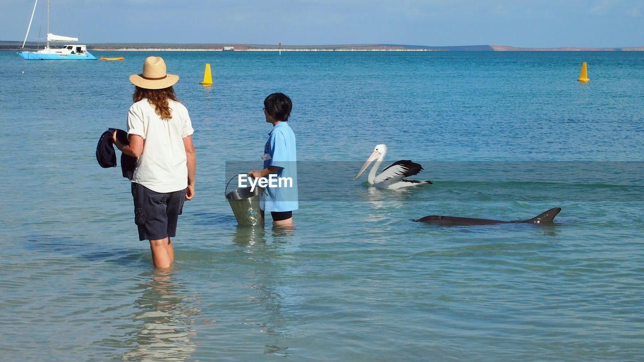 PEOPLE STANDING IN SEA