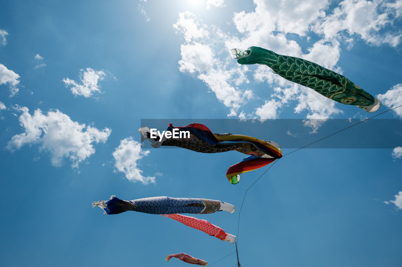 Low angle view of carp streamers flying against sky