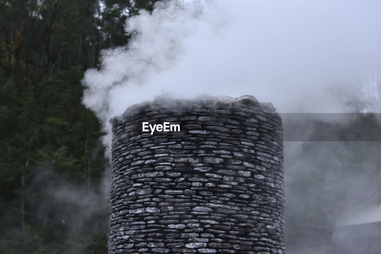 SMOKE EMITTING FROM CHIMNEY AGAINST TREES