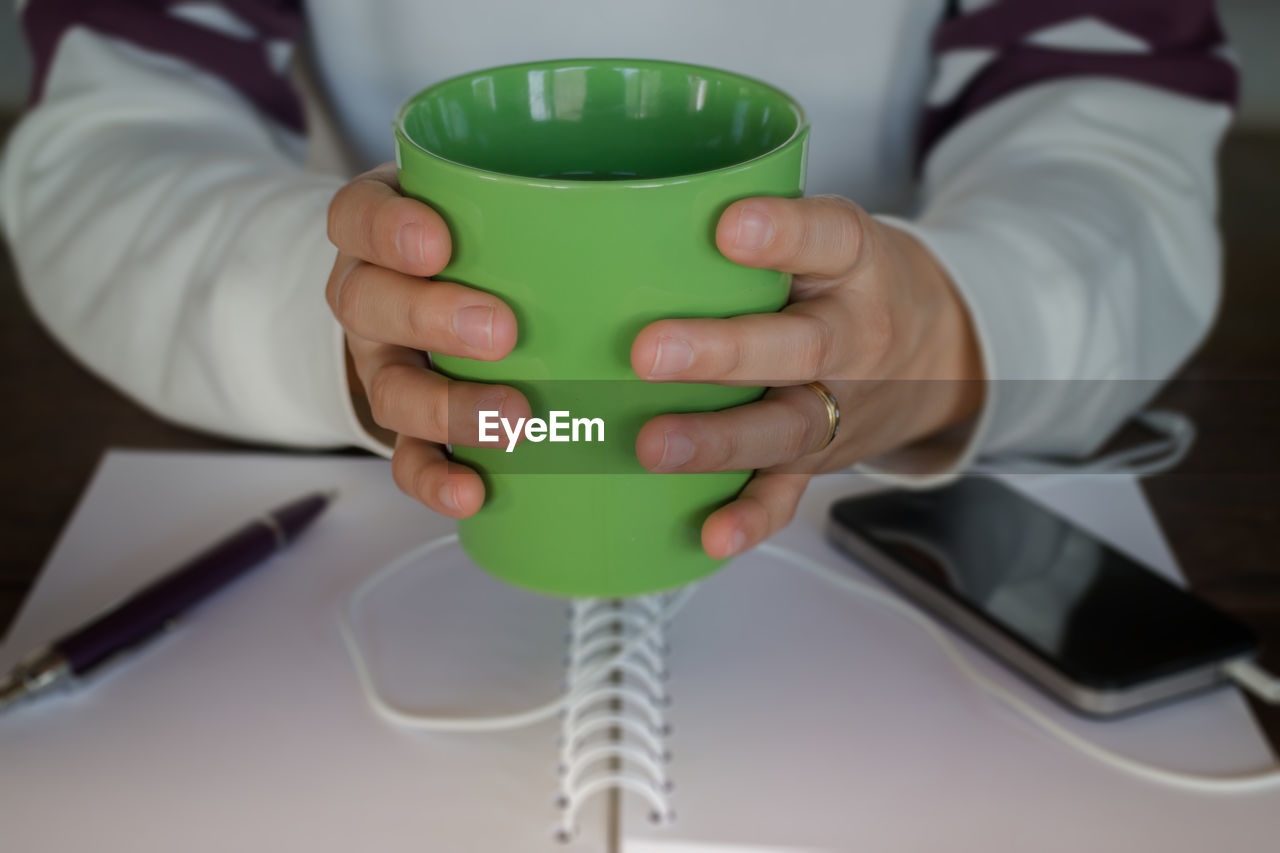 Midsection of woman holding mug