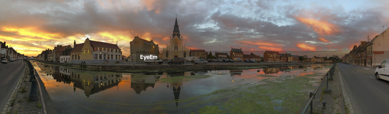 Panoramic view of buildings against cloudy sky during sunset