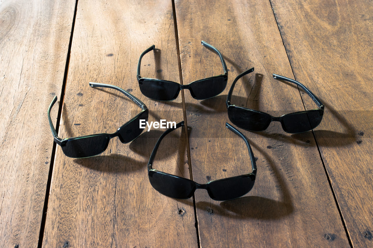 HIGH ANGLE VIEW OF EYEGLASSES ON WOODEN TABLE