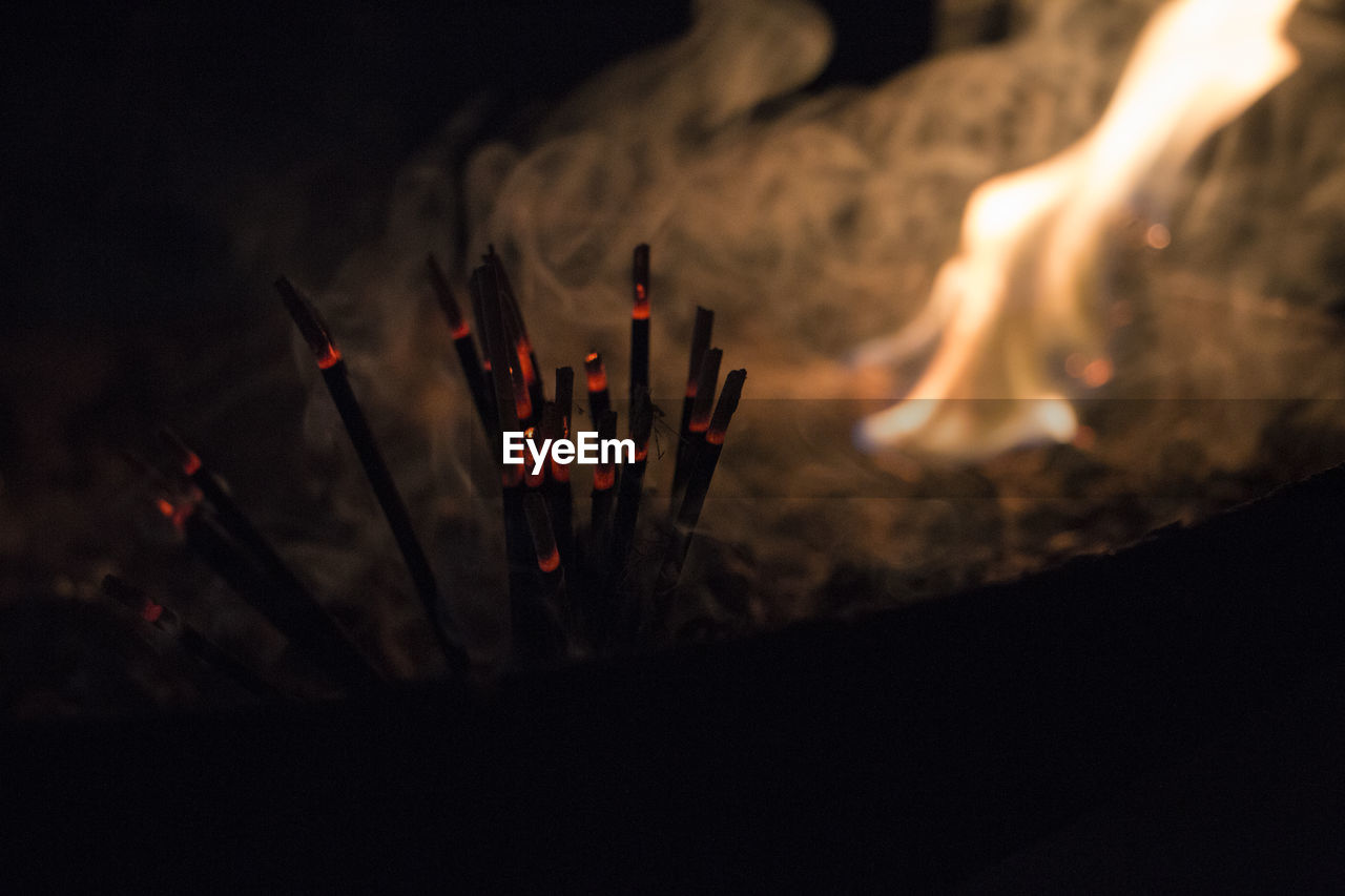 Close-up of incense sticks at night