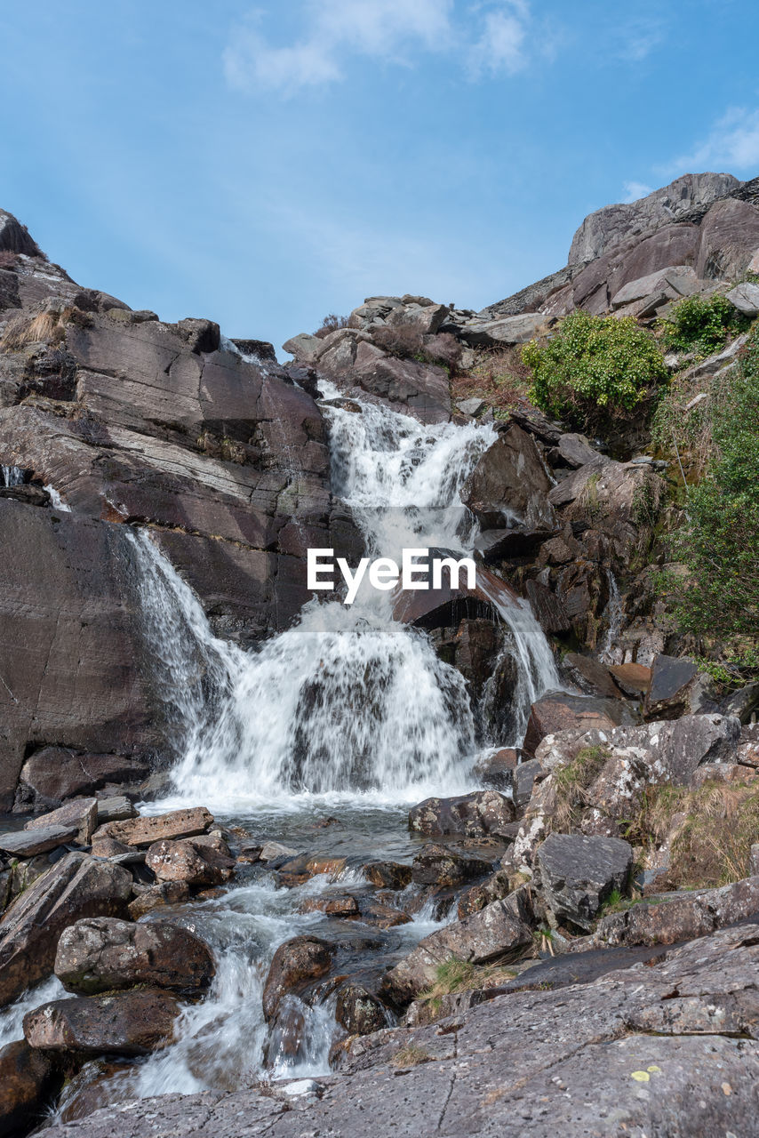 VIEW OF WATERFALL ALONG ROCKS